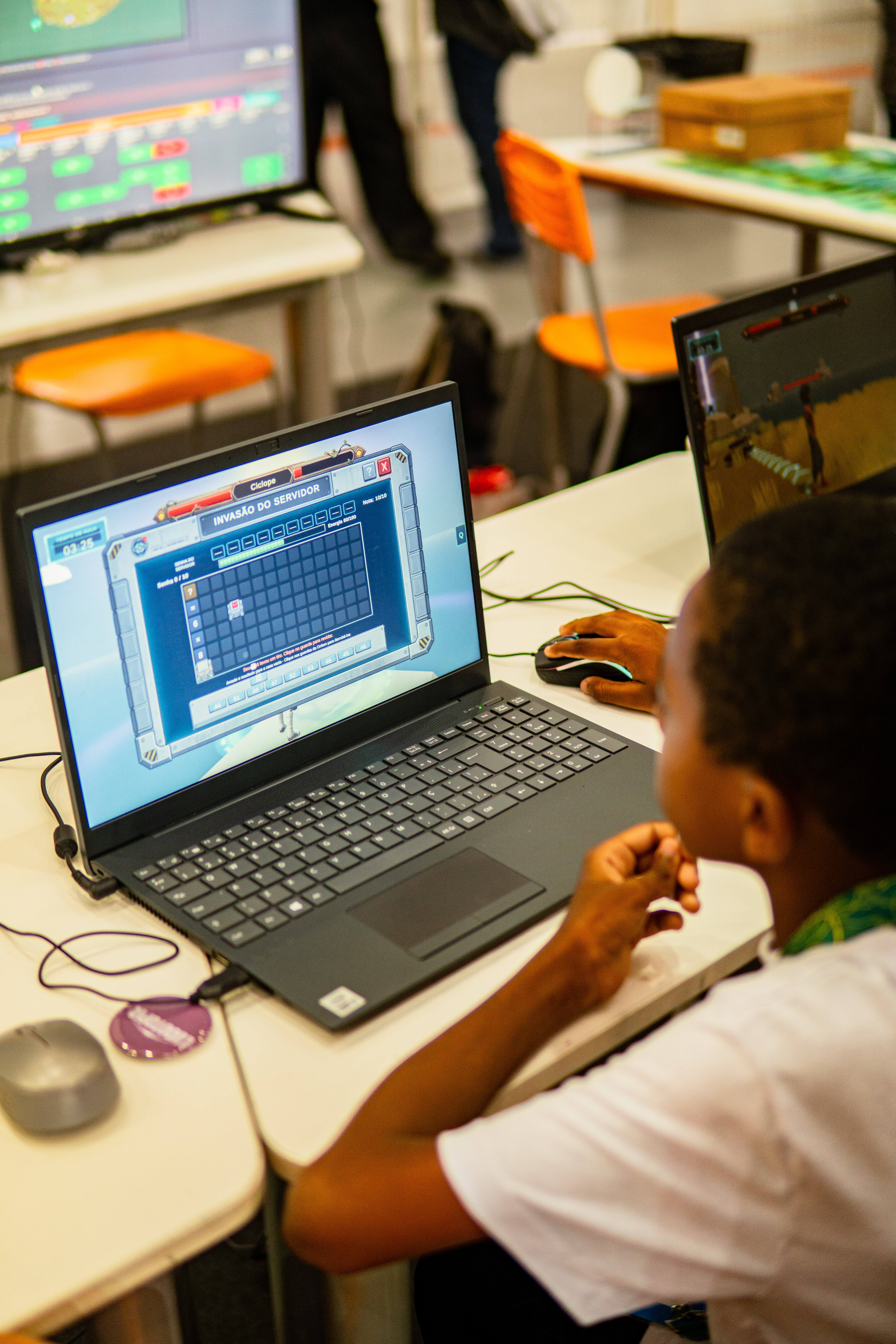 Criança jogando Ludotopia em um notebook na escola